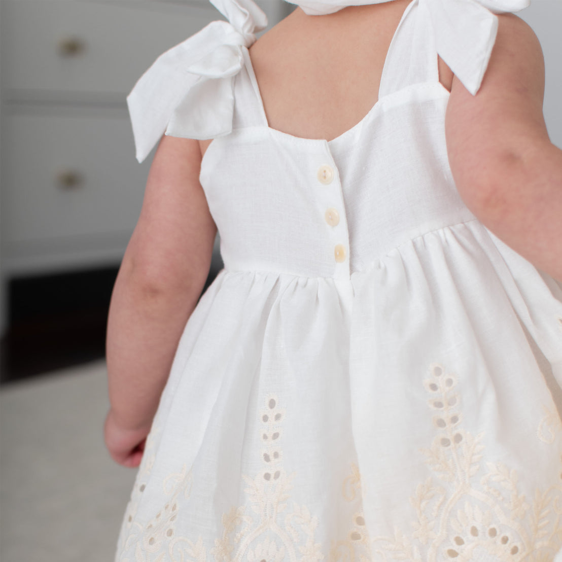 Detail of the ivory Ingrid Romper Dress featuring the buttons on the back