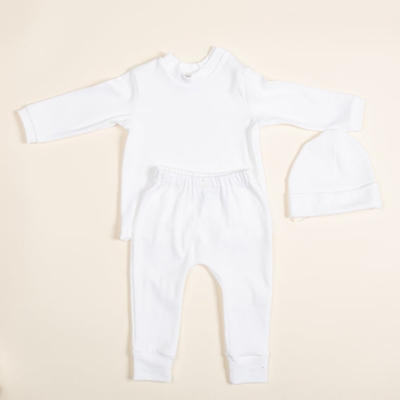 Introducing the Ivory Pima Top & Leggings set, a handcrafted baby outfit from the USA. This ensemble, featuring a long-sleeved top, matching leggings, and a cozy hat is crafted from soft Pima cotton. Arranged on a light background, it presents a simple yet elegant minimalist design.