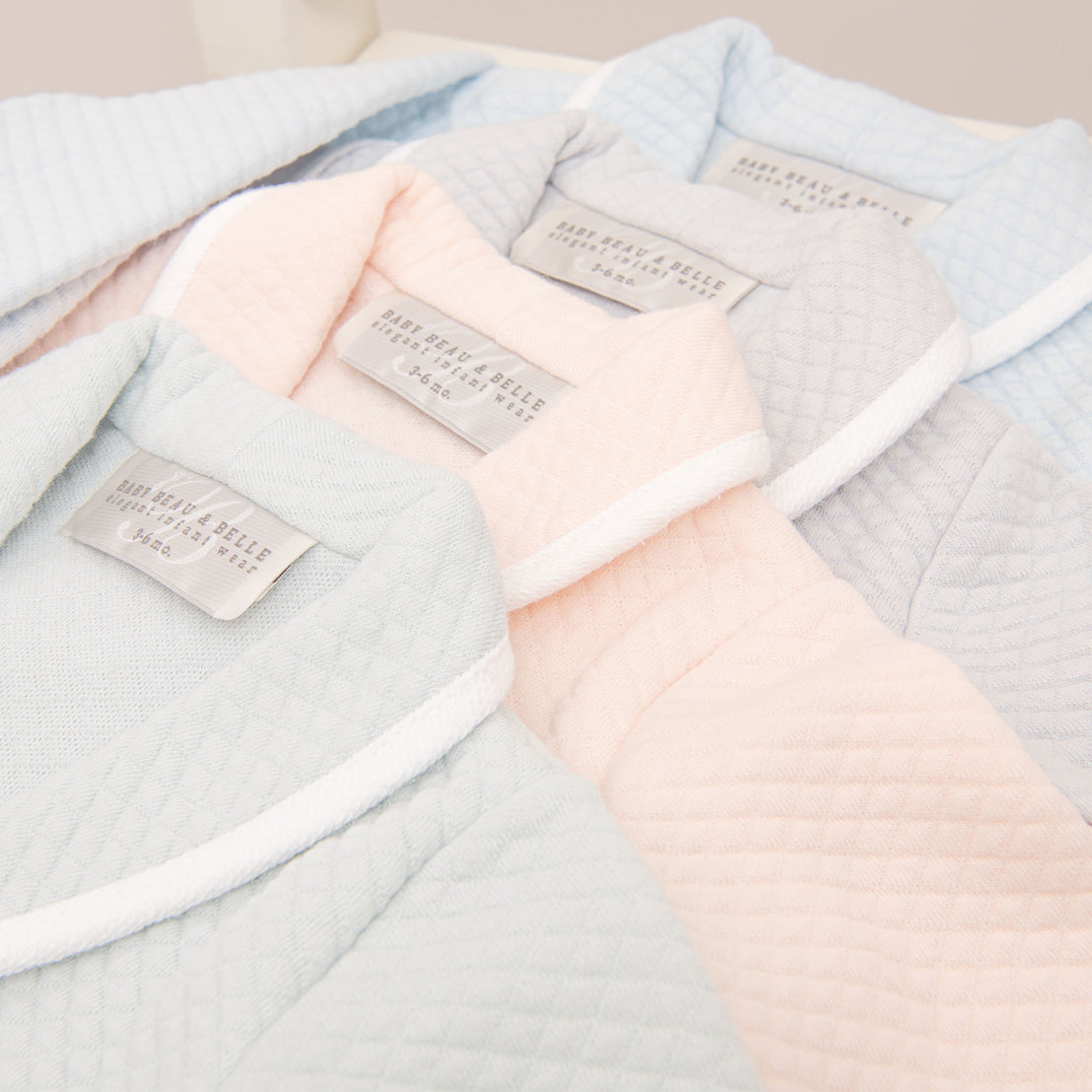 Close detail showing the collar of four Asher Baby Boy Jackets, including the colors grey, pink, powder blue, and soft teal.