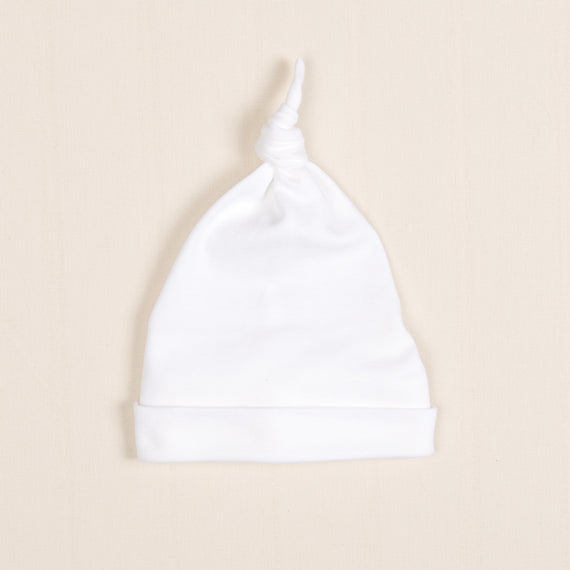 The Ivory Pima Knot Cap is highlighted on a simple beige background.