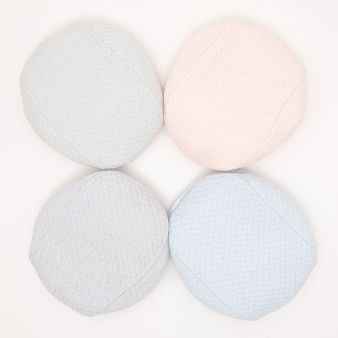 Flat lay photo of the four Asher Quilted Newsboy Caps in colors grey, pink, powder blue and soft teal.