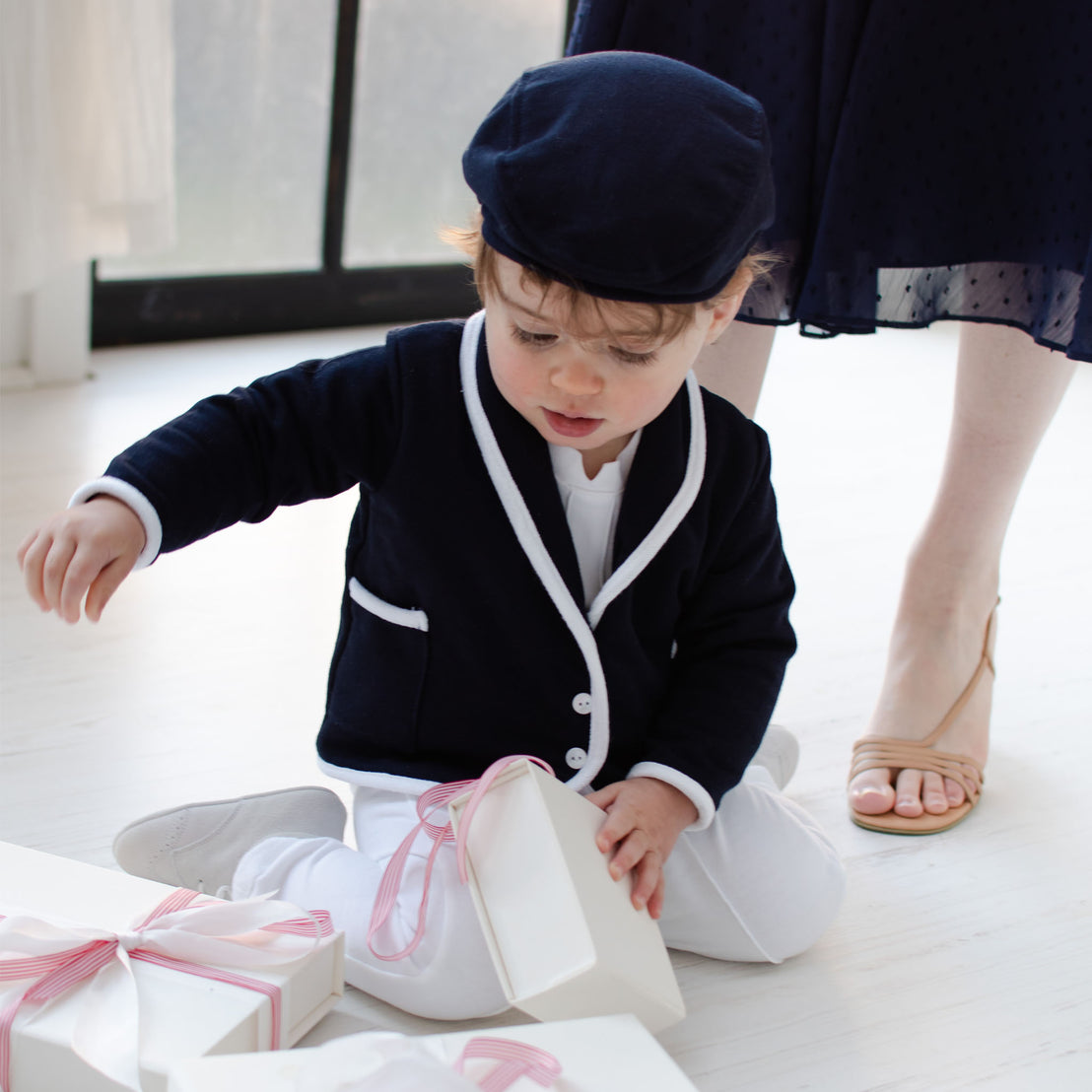  He is wearing the Elliott 3-Piece Suit, including jacket, pants, and onesie (and matching newsboy cap).