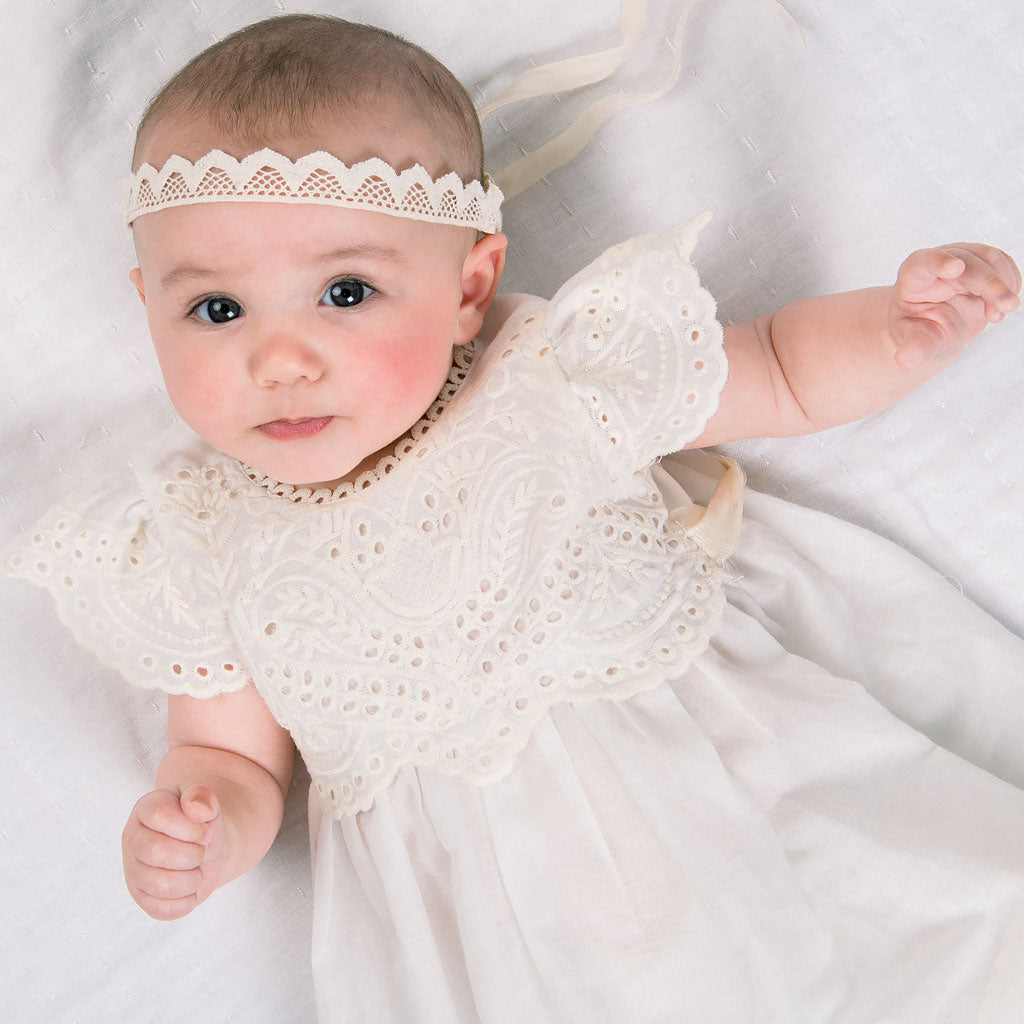 Baby wearing the Ingrid Lace Headband and ivory Ingrid Romper Dress.