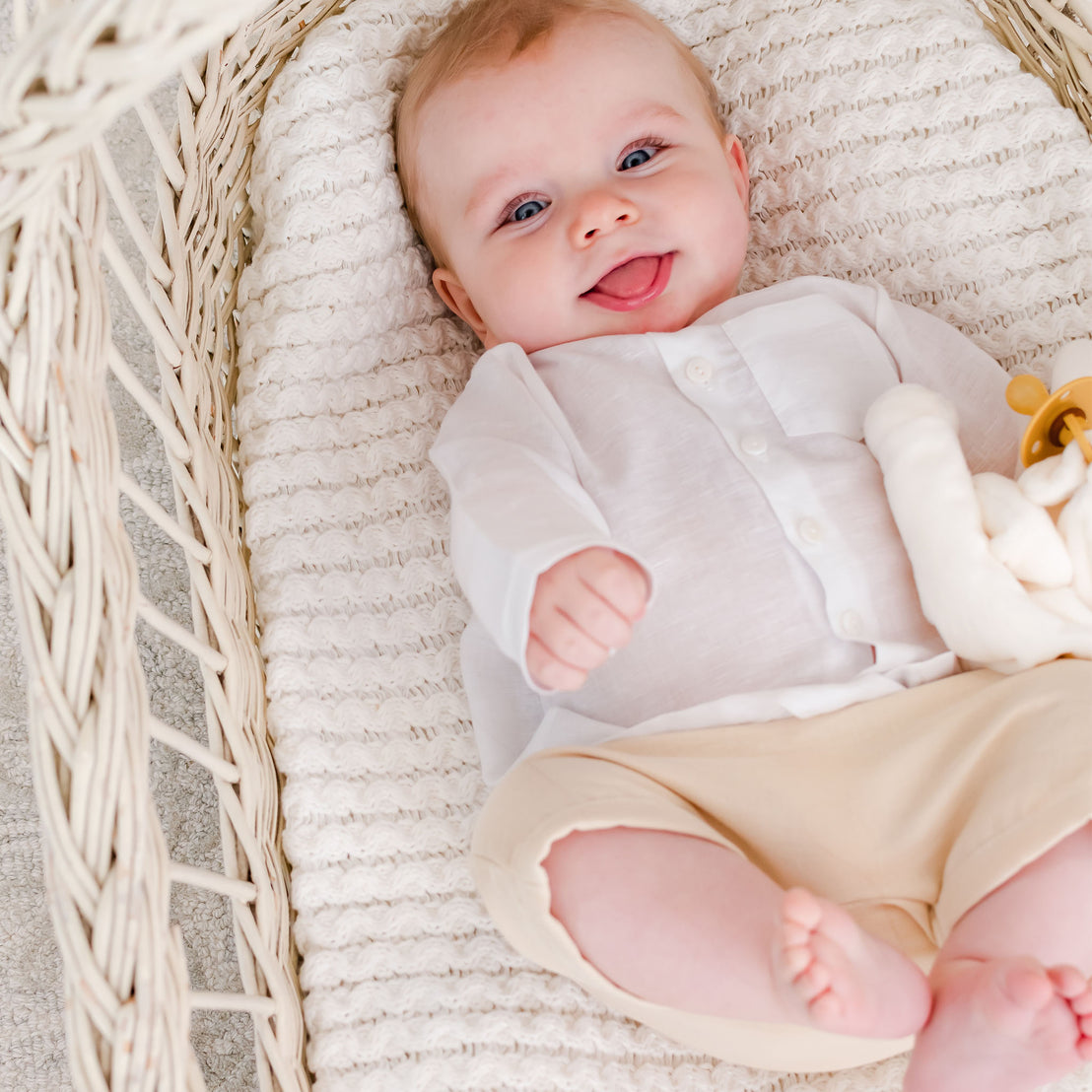 Smiling baby boy in a crib wearing the Silas White Linen Shirt
