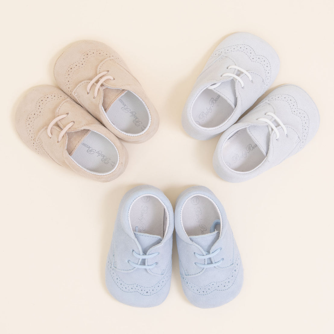 Flat lay photo of three pairs of Theodore Suede Shoes. Made from 100% suede with detailed edging. Available in colors blue, grey, and tan.