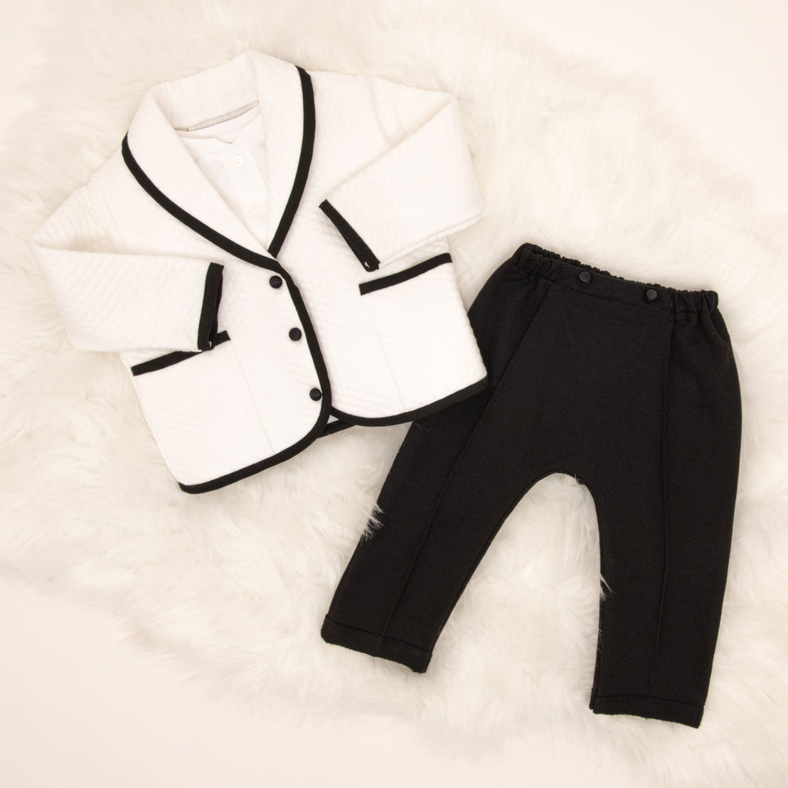 The James 3-Piece Suit laid flat, showing the white quilted jacket with black trim and black pants.