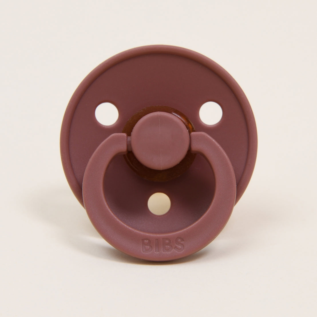 A close-up image of a Bibs Pacifier Set in Peach Sunset & Woodchuck, featuring a round natural nipple. The brand "bibs" is embossed at the top. This item makes an upscale baby gift.