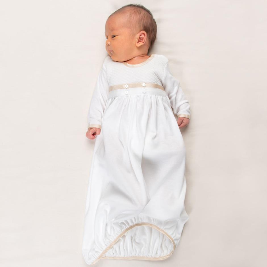 Newborn baby boy wearing the Liam Cotton Newborn Gown crafted from soft white pima cotton, ivory quilted cotton bodice, and detailed with silk trim in a shade of champagne