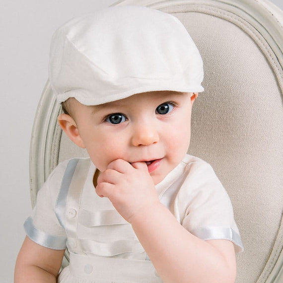 Baby boy sitting in a chair and wearing the Owen Linen Newsboy and matching Romper