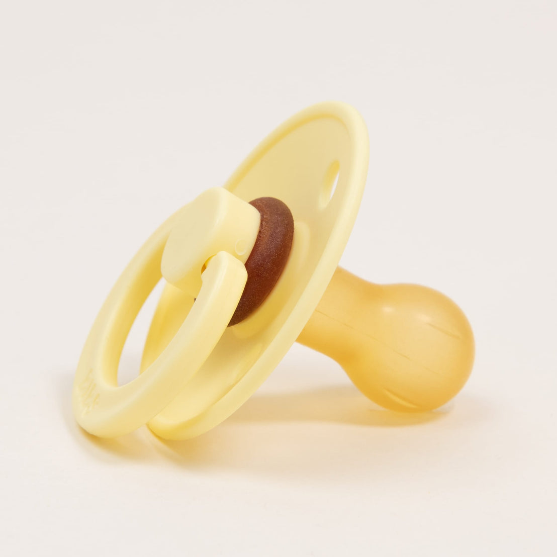A yellow Bibs Pacifier in "sunshine" color with a natural nipple and brown handle, isolated on a white background.