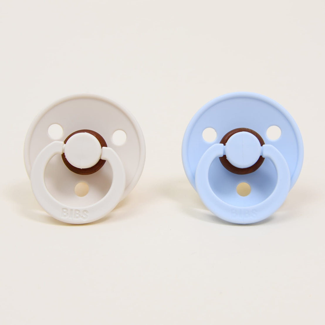A Bibs Pacifier Set featuring two pacifiers in two different colors: "ivory" and "baby blue".