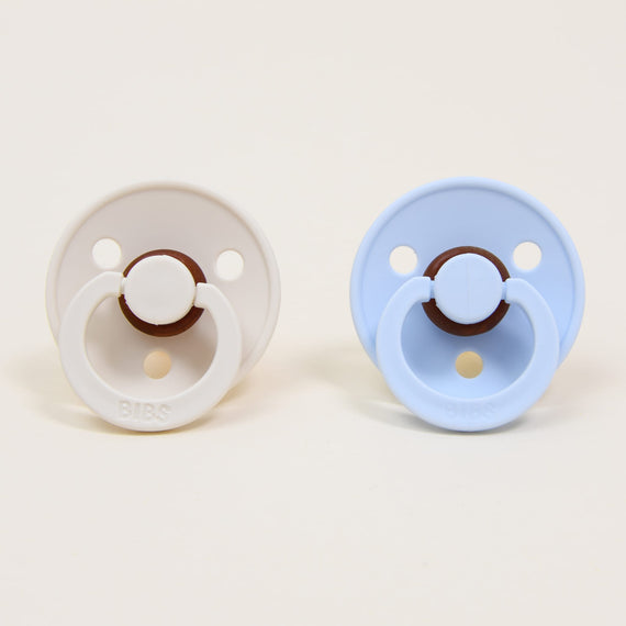A Bibs Pacifier Set featuring two pacifiers in two different colors: "ivory" and "baby blue".