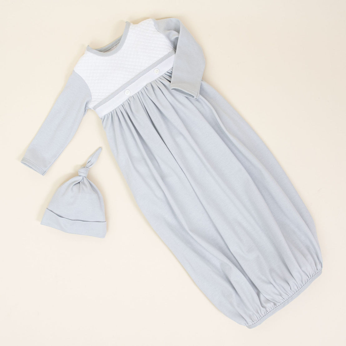 Enhance your little one's wardrobe with the Grayson Newborn Gift Set—now available at a 10% discount. This light blue set includes an infant gown made from soft pima cotton, featuring long sleeves and elegant white quilted detail on the chest. Complete with a matching knotted hat, it is an ideal personalized baby gift. The gown also offers gathered elastic at the hem for added comfort.