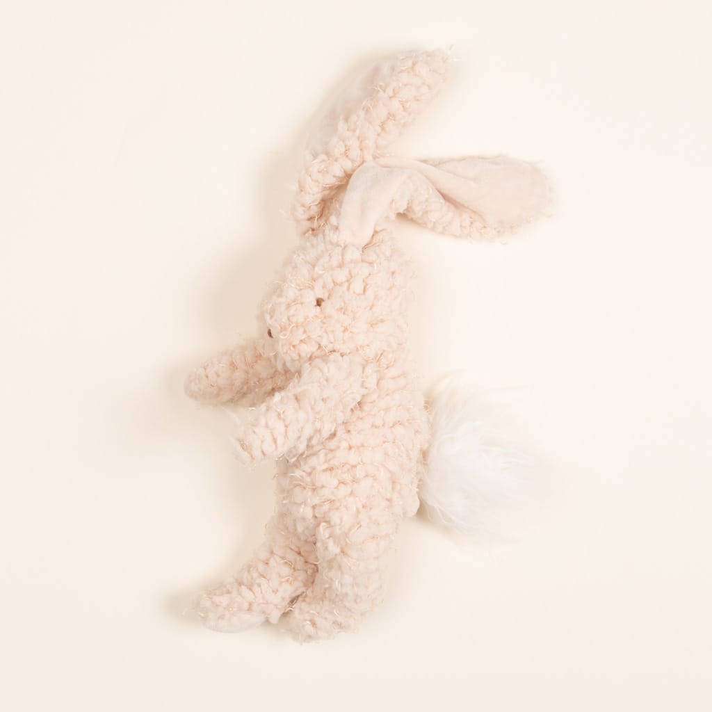 The Harey Bunny, a soft and plush toy, is the ideal baby gift with its fluffy texture, large ears, and bushy tail. Its pale cream color is beautifully complemented by its embroidered face, set gently against a light background.