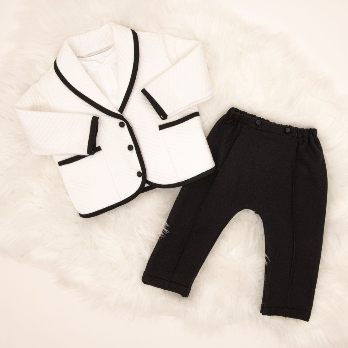 The James 3-Piece Suit laid flat, showing the white quilted jacket with black trim and black pants.