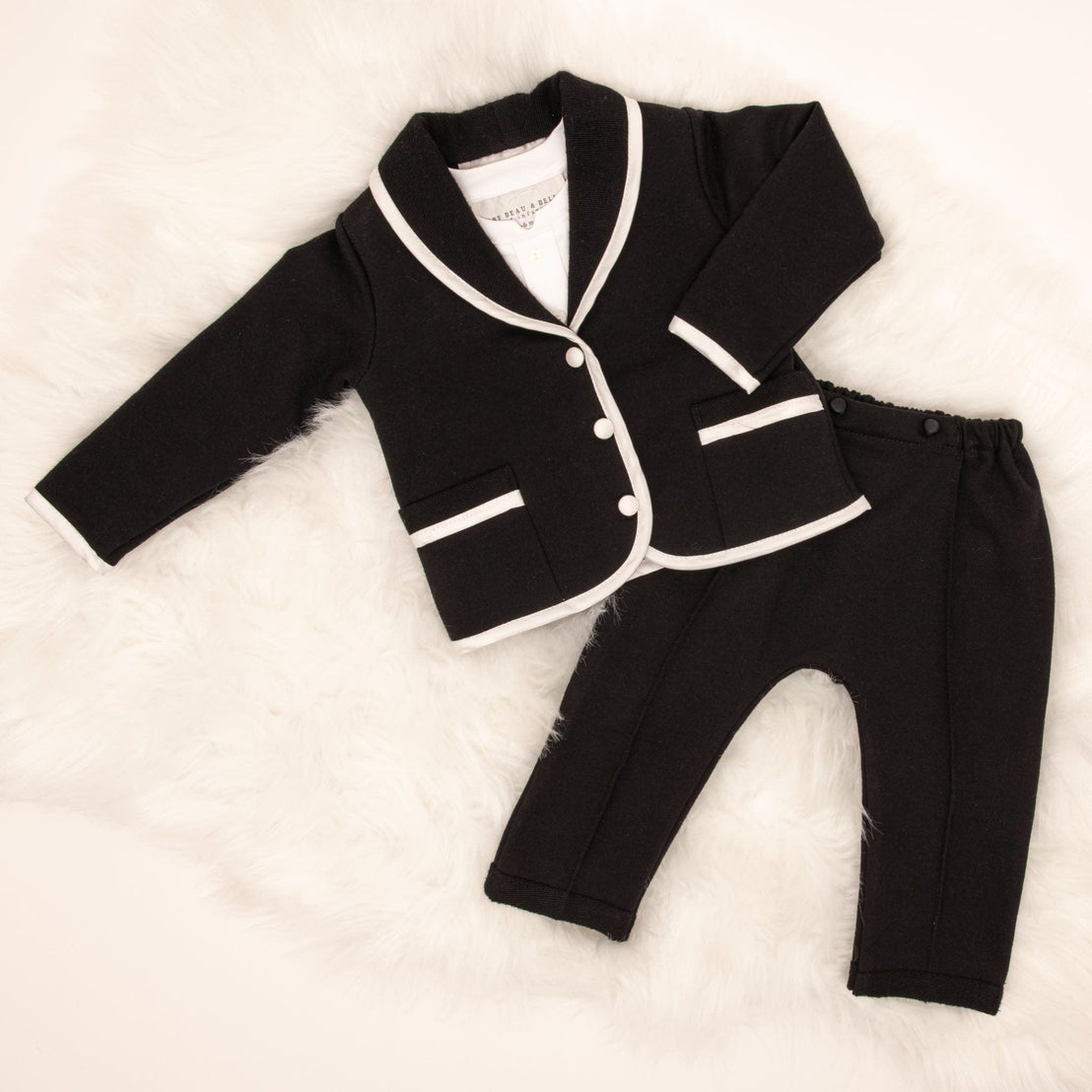 The James 3-Piece Suit laid flat, featuring a black jacket with white trim and matching black pants.