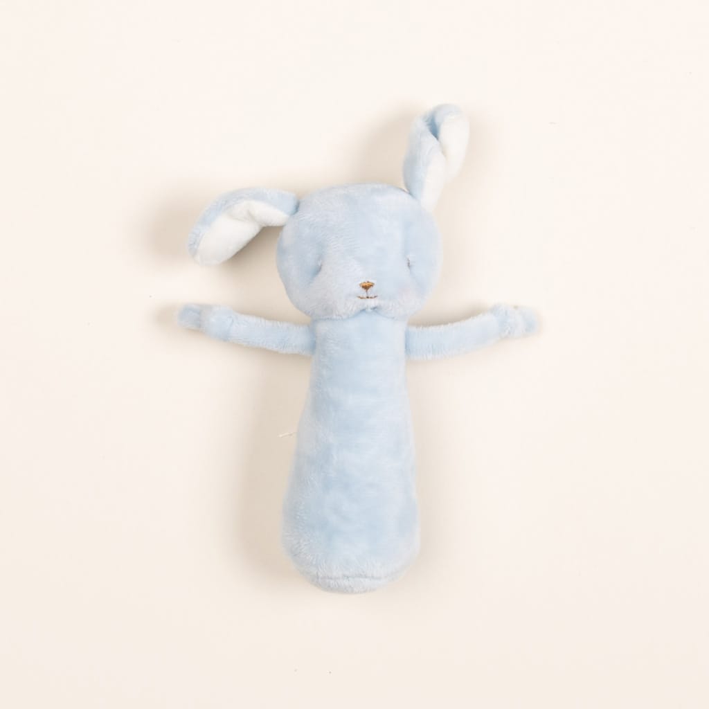 Upscale soft blue Puppy Chime Rattle with long ears and arms, lying flat on a vintage light beige background.