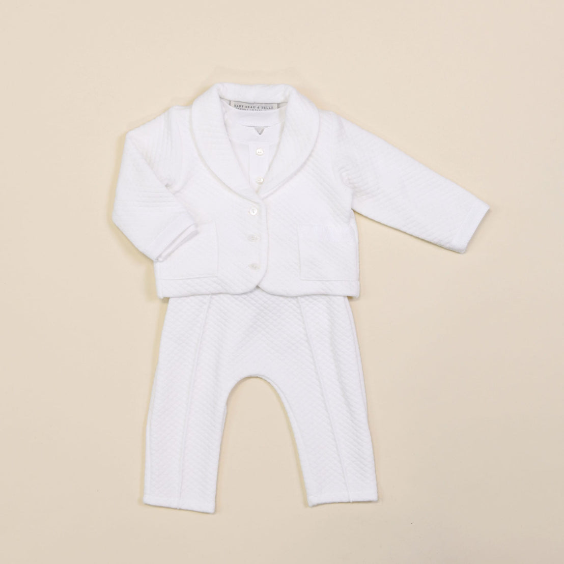 Introducing the Elijah Newborn 3-Piece Suit, a stylish white ensemble set against a light beige background, making it an ideal choice for a coming home outfit. This adorable suit includes a quilted long-sleeve jacket with buttons and matching pants, both designed with a soft and comfortable texture.