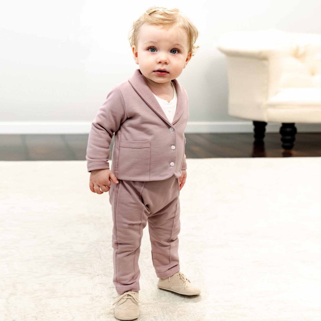 Baby boy standing in mauve suit